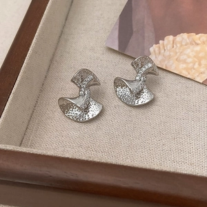 Macro detail of silver hammered earrings featuring a vertical row of zircon stones