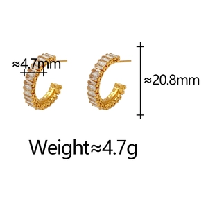 Detailed view of C-shaped gold hoop earrings with rectangular cubic zirconia stones