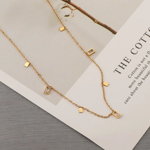 Detail of a 18K gold-plated double-layer snake chain necklace with rectangular zircon charms