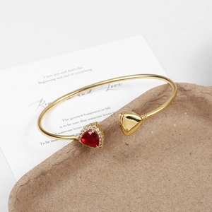 Minimalist gold-plated bangle with emerald glass and red triangular gemstone detailing