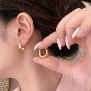 Minimalist thick gold teardrop hoop earrings showing glossy finish and chunky design