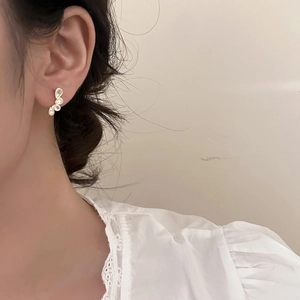 Elegant teardrop crystal stud earrings in gold finish worn by model with lace collar