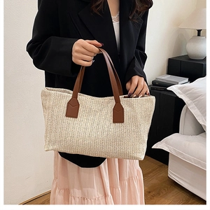 Close-up of beige woven tote bag with brown leather handles in a cozy home setting