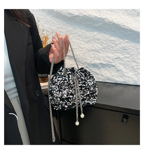 Detail of sequined bucket bag featuring silver chain strap and elegant pearl charm accents