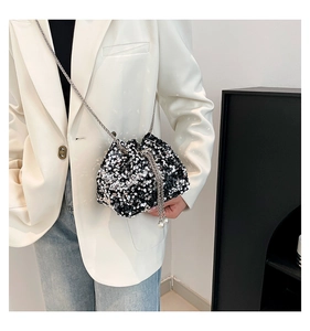 Detail of sequin bucket bag featuring drawstring closure, pearl charms, and silver chain strap