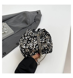 Detail of silver sequin bucket bag featuring chain drawstring and pearl accents