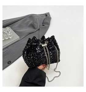 Detail of black sequin bucket bag featuring silver chain and white pearl drawstring
