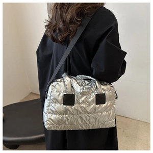 Silver quilted puffer tote bag shown on model highlighting metallic texture and style