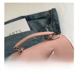 Macro detail of soft pink cream-style handbag handle with textured leather finish