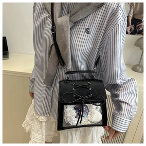 Détail du sac ita noir avec dentelle, nœud et fenêtre d'affichage transparente