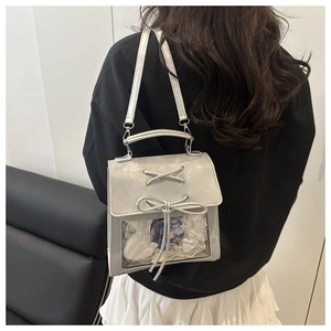 Detail of silver glitter ita bag with clear window and ribbon decor on person