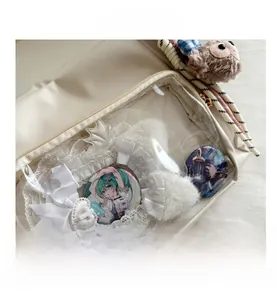 Detail of cream itabag with lace trim, white ribbon bows and clear display window