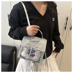 Dettaglio della borsa Ita argento con finestra in PVC trasparente, pizzo e fiocchi decorativi