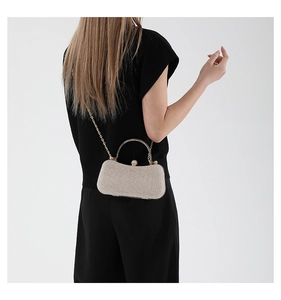 Detail of champagne gold glitter evening bag with crystal clasp and metal ring handle
