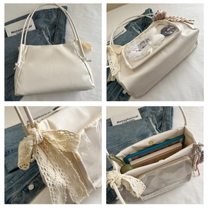 Close-up of cream white ita bag showing transparent PVC window and side lace bow details