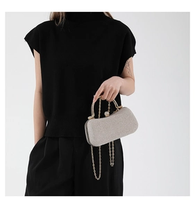 Detail of silver glitter clutch bag with rhinestone handle and metal chain for evening