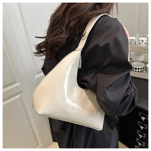 Macro shot of off-white patent leather hobo bag with sleek curved silhouette and gloss