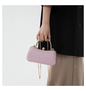 Macro shot of glittery pink evening clutch with gold metal frame and crystal clasp detail
