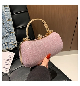 Close-up of pink glitter evening bag with wavy texture and crystal-inlaid gold handle