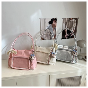 Detail view of large tote bags with transparent PVC windows and plush bear charms