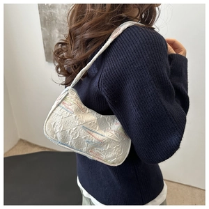 Detailed view of white faux leather underarm bag with vibrant wavy stitching texture