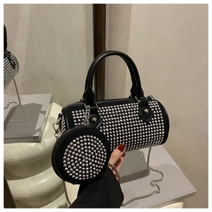 Detail of black cylinder bag with silver studs, matching coin purse and chain strap