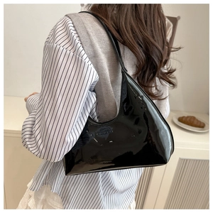 Detail of a black patent leather crescent bag featuring KAI PAP LUFF embossed logo