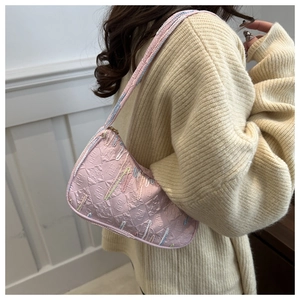 Detail of pink nylon dumpling bag with colorful embroidery on textured fabric