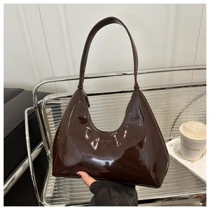 Detail of dark brown patent leather hobo bag with glossy finish and embossed logo