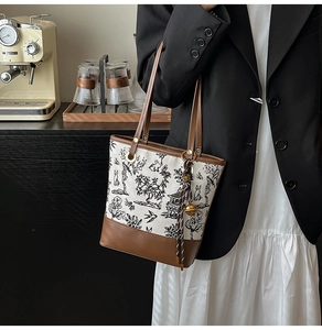 Détail du sac seau en toile brodée avec poignées en cuir et motifs d'art à l'encre chinoise