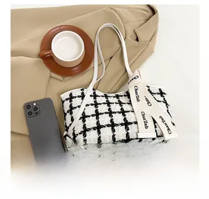 Détail d'un sac cabas à carreaux noir et blanc avec ruban décoratif beige de marque