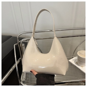 Detail of creamy patent leather crescent bag with embossed logo and metal zipper