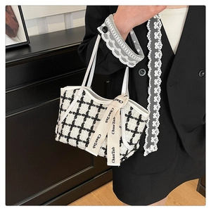 Détail du sac cabas en tweed noir et blanc avec ruban élégant et texture tissée
