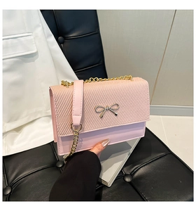 Dettaglio borsa rosa con catena e fibbia a fiocco su seduta in pelle di lusso