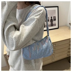 Detail of light blue quilted shoulder bag with rainbow embroidery and FF monogram patterns