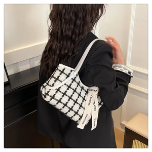 Détail du sac à bandoulière en tweed à carreaux avec lanière en cuir blanc et ruban élégant