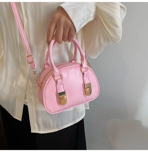Dettaglio della borsa bowling rosa con finitura in pelle liscia e dettagli dorati