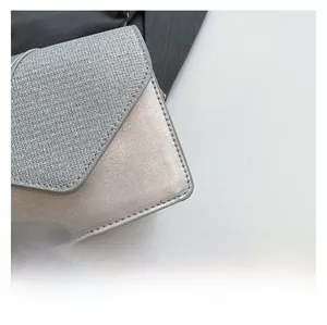 Macro detail of silver envelope bag with glitter fabric and metallic leather finish