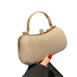 Sparkling gold sequin evening clutch bag with round metal handle and crystal clasp closure