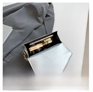 Interior view of the silver metallic crossbody bag showing capacity for phone and makeup
