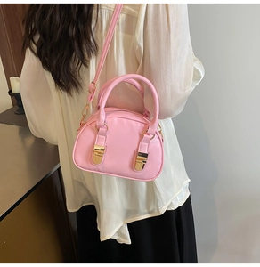 Detailed view of a pink Boston bag showing the smooth PU leather and gold metal hardware