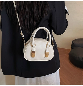 Detailed view of the off-white bowling bag with gold hardware shown on a model