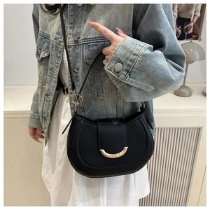 Close-up of black half-moon bag featuring a distinctive gold crescent metal buckle closure