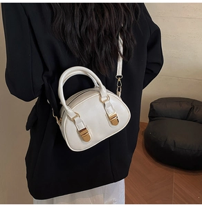 Dettaglio della borsa Boston vintage bianca con finiture dorate indossata dalla modella