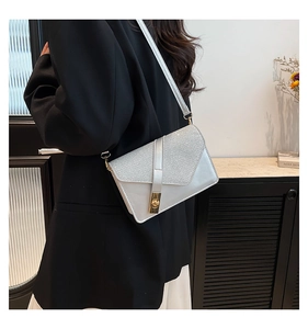 Detailed view of silver sequin crossbody bag with metal twist lock and slim strap