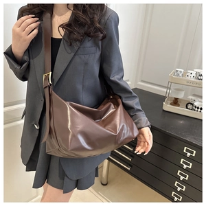 Dettaglio della tracolla regolabile con fibbia dorata su borsa tote vintage in pelle marrone