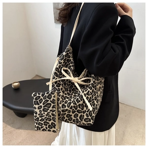 Detail of leopard print tote bag with cream ribbon bow and matching small zipper pouch