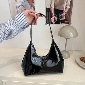 Glossy black patent leather crescent underarm bag with embossed logo in a French setting