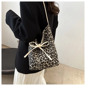 Detail of leopard print tote bag with a cream ribbon bow and drawstring closure