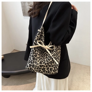 Detail of leopard print tote bag with stylish cream drawstring bow and canvas texture